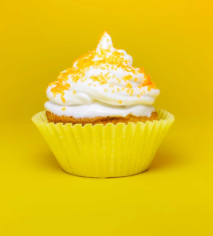 cupcake with white frosting and lemon zest on top.