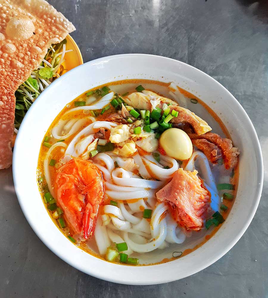 noodle soup topped with shrimp.