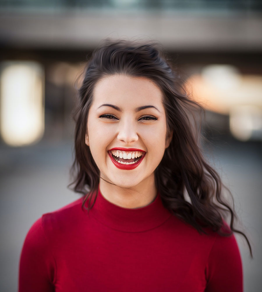 woman with black hair, red shirt, and red lipstick laugh-smiling.